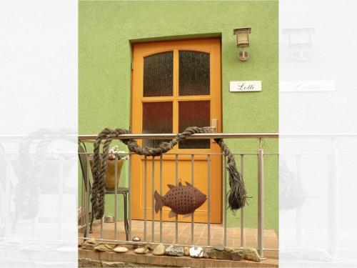 ヘリングスドルフにあるFerienwohnung Lottiの手すりの魚と扉のある家