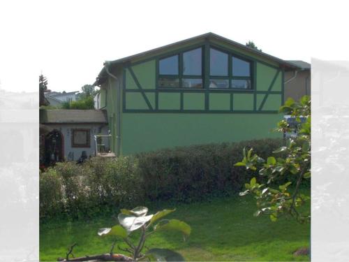 ヘリングスドルフにあるFerienwohnung Lottiの庭の上に窓のある緑の家