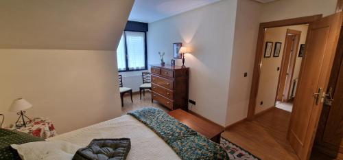 a bedroom with a bed and a dresser in a room at Raitán 1 - Dúplex en Colunga para 4 con piscina compartida - VUT-4300-AS in Colunga