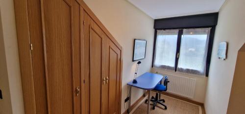 a room with a blue desk and a window at Raitán 1 - Dúplex en Colunga para 4 con piscina compartida - VUT-4300-AS in Colunga