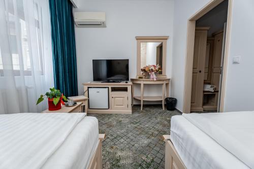 a hotel room with two beds and a television at Hotel Rin in Sibiu