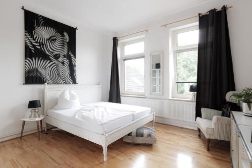 een witte slaapkamer met een bed en 2 ramen bij LULEX I - Luxus Apartment Krefeld Alexanderplatz in Krefeld