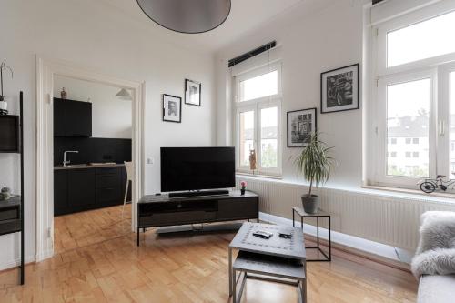 een woonkamer met een flatscreen-tv en een bank bij LULEX I - Luxus Apartment Krefeld Alexanderplatz in Krefeld
