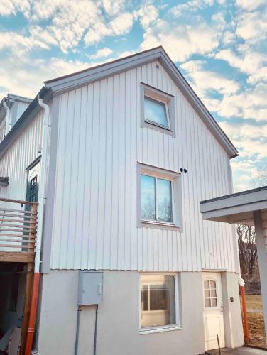 a white house with windows on the side of it at Lovely 3-bed Flat In Stockholm in Sollentuna