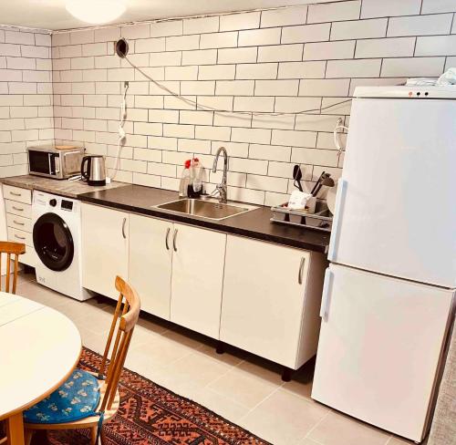 a kitchen with a white refrigerator and a sink at Lovely 3-bed Flat In Stockholm in Sollentuna