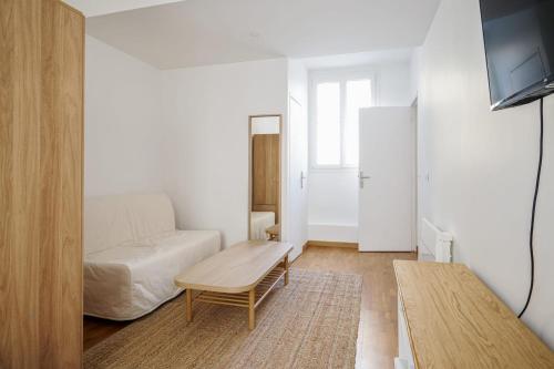 un salon avec un canapé et une table dans l'établissement Appartement Amavel - Welkeys, à Paris