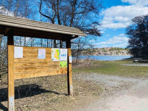 a sign in a park next to a body of water at Lovely 3-bed Flat In Stockholm in Sollentuna
