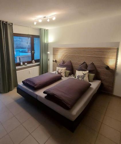 a large bed in a bedroom with a window at Ferienwohnung Lina mit toller Terrasse im Schwarzwald in Bernau im Schwarzwald