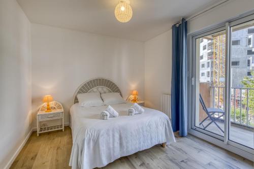 une chambre avec un lit et une grande fenêtre dans l'établissement Les mats du lac, à Annecy