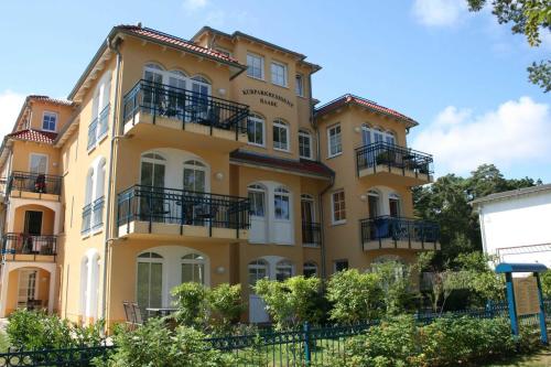 un grand bâtiment jaune avec balcon. dans l'établissement Kurparkresidenz Baabe - FeWo 14, à Baabe