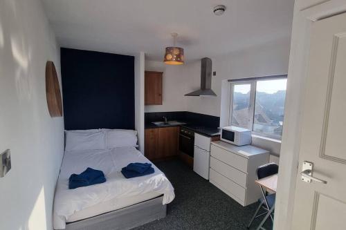 a small bedroom with a bed and a kitchen at Studio Flat in Nottingham