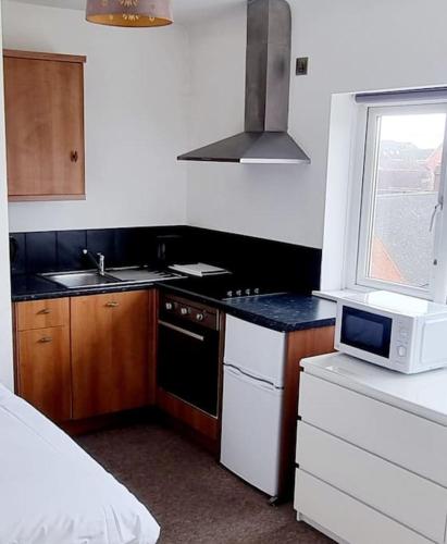 a small kitchen with a sink and a microwave at Studio Flat in Nottingham
