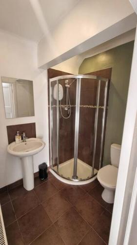 a bathroom with a shower and a toilet and a sink at Studio Flat in Nottingham