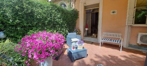 a patio with purple flowers and a bench on a house at Hotel Canarco in Viareggio