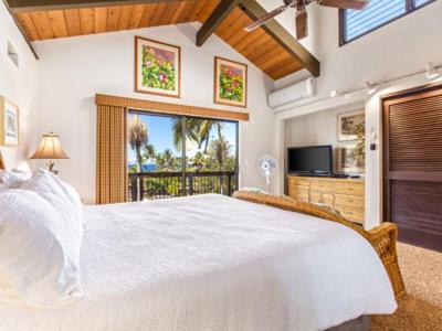 1 dormitorio con 1 cama blanca grande y balcón en Kanaloa at Kona by OUTRIGGER en Kailua-Kona