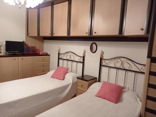 Duas camas com almofadas cor-de-rosa num quarto em txukuna em Amorebieta-Echano