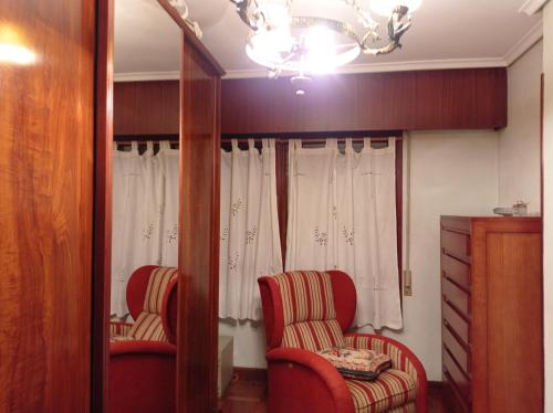 duas cadeiras vermelhas e um espelho num quarto em txukuna em Amorebieta-Echano