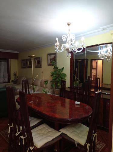 comedor con mesa y lámpara de araña en txukuna en Amorebieta-Etxano