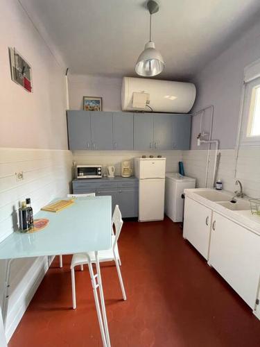 une petite cuisine avec une table et un évier dans l'établissement T2 dans le vieil Antibes, à Antibes