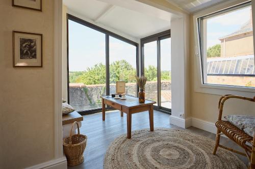 a living room with a table and a large window at Gîte Des Caves Secrètes in Tiffauges