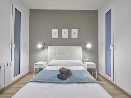 una camera da letto bianca con un letto e asciugamani di Gran Via Terrace Barcelona a Barcellona