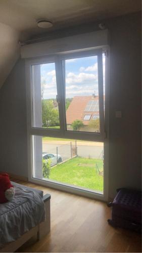 um quarto com uma grande janela com vista em Chez lulu et aurelie em Meroux