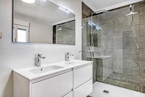 un bagno bianco con lavandino e doccia di La Sella a Pedreguer
