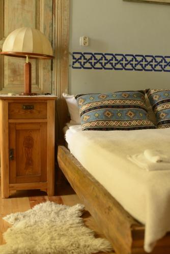 a bedroom with a bed and a lamp and a rug at Dzveli Galavani -Old Wall in Tʼelavi