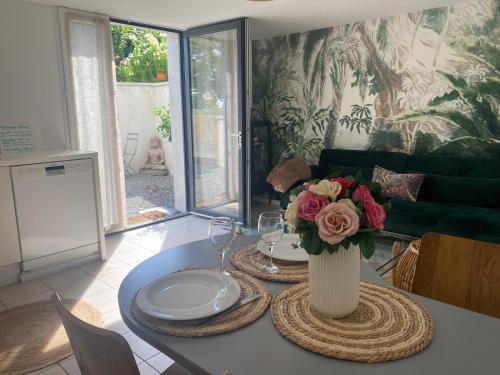 uma mesa de jantar com um vaso de flores em Beldi, Bel appartement dans un environnement calme em Montgermont