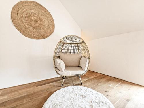 uma cadeira de vime num quarto com uma parede branca em Cloud 9 em Ralingen