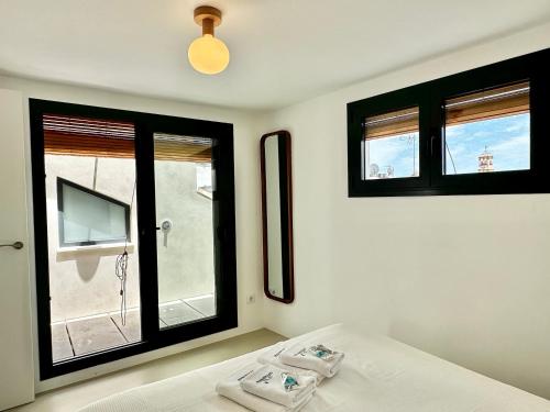 a bedroom with a bed and two windows and a television at Peral Old Town Penthouse II - EaW Homes in Marbella