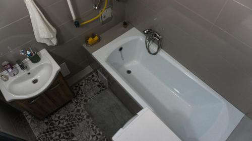 a bathroom with a white tub and a sink at H22 Apartman in Eger