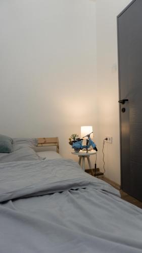 a bedroom with a bed and a desk with a lamp at H22 Apartman in Eger