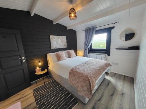 Un dormitorio con una cama grande y una ventana en Blue Haven Lodge, en Doolin