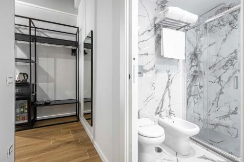a white bathroom with a toilet and a sink at Home at Rome Luxury Navona in Rome