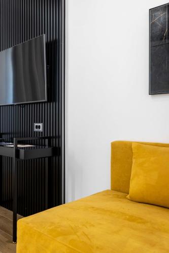 a bedroom with a yellow bed and a television at Home at Rome Luxury Navona in Rome