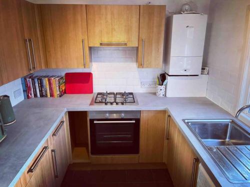 a small kitchen with a stove and a sink at Chester/Handbridge sleeps 9 + Netflix in Hough Green