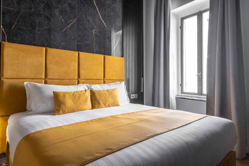 a bedroom with a large bed with a yellow headboard at Home at Rome Luxury Navona in Rome