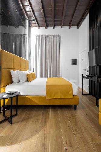 a bedroom with a large bed with a yellow blanket at Home at Rome Luxury Navona in Rome