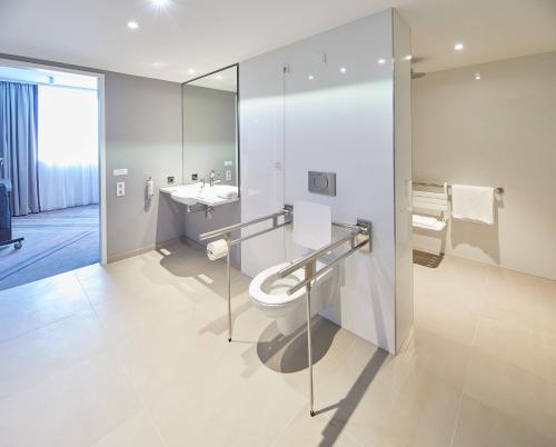 a bathroom with a toilet and a sink and a mirror at Premier Inn Karlsruhe City Am Wasserturm in Karlsruhe