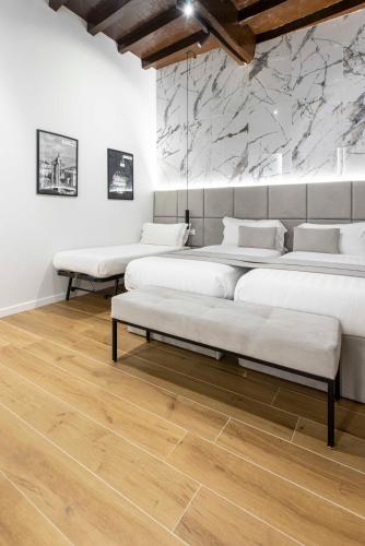 a room with four beds and a stone wall at Home at Rome Luxury Navona in Rome