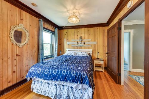 ein Schlafzimmer mit einem Bett in einem Zimmer mit Holzwänden in der Unterkunft Waterfront Fox Lake Vacation Rental with Fire Pit! in Fox Lake