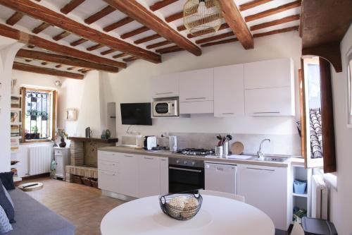 a kitchen with white cabinets and a table at CIRIBACCO ROOMS in Macerata