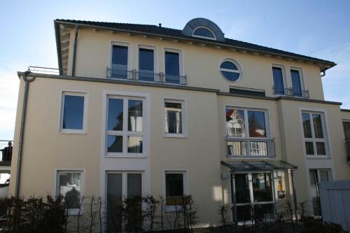 オストゼーバート・ゼリンにあるHaus Möwe II - Ferienwohnung 10の青い窓とバルコニーが備わる白い家