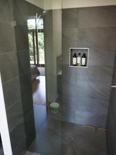 a bathroom with a shower with a glass door at Kaalba in Maleny