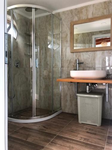 een badkamer met een douche en een wastafel bij Kiparissi Guesthouse in Himare