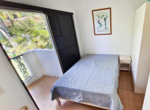 ein kleines Schlafzimmer mit einem Bett und einem Fenster in der Unterkunft Apartamento - Cond. Winbledon - Praia Toninhas in Ubatuba