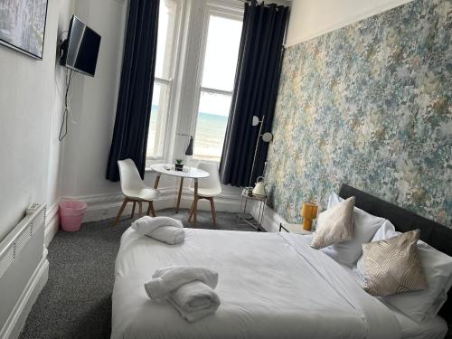 a bedroom with a bed with towels on it at OYO Marine Parade Hotel, Eastbourne Pier in Eastbourne