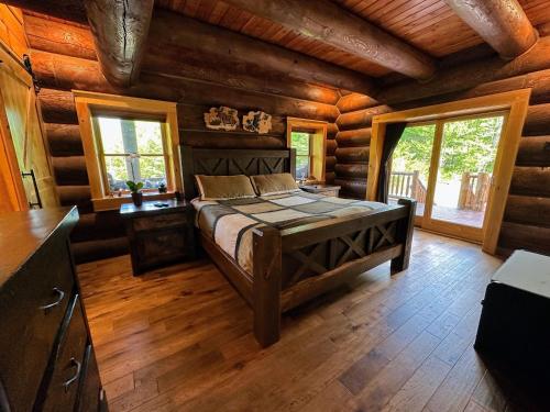 a bedroom with a bed in a log cabin at WML stunning log home in Bretton Woods, AC, 2-person Jacuzzi, indoor and outdoor fireplaces, & more! in Bretton Woods