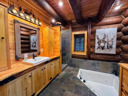 łazienka z wanną i umywalką w drewnianej kabinie w obiekcie WML stunning log home in Bretton Woods, AC, 2-person Jacuzzi, indoor and outdoor fireplaces, & more! w mieście Bretton Woods